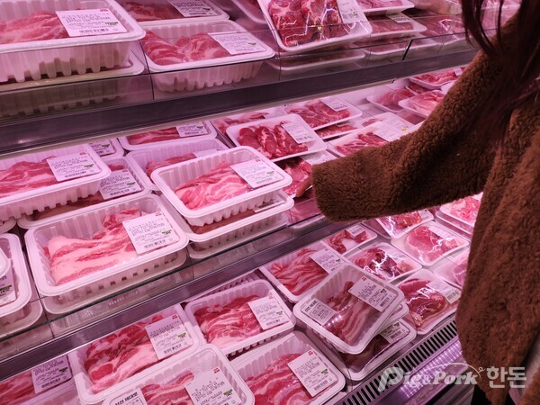 한 소비자가 대형마트에서 돼지고기를 고르고 있다. (해당 기사와 관련 없음)